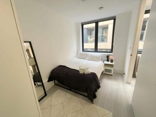 a white bedroom with a bed and a window at 2 BDRM Contemporary Central London Apartment in London