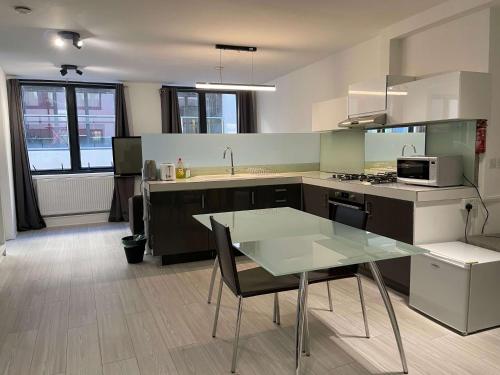 a kitchen with a glass table and a counter top at 2 BDRM Contemporary Central London Apartment in London