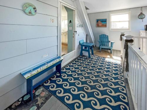 a hallway with a staircase with a blue chair and a rug at Sweet Serenity - Y846 condo in York