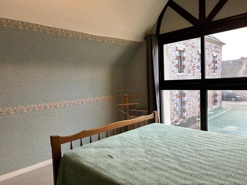 ein Schlafzimmer mit einem Bett und einem großen Fenster in der Unterkunft 539 - Maison 5 personnes en plein cœur d'Erquy. in Erquy