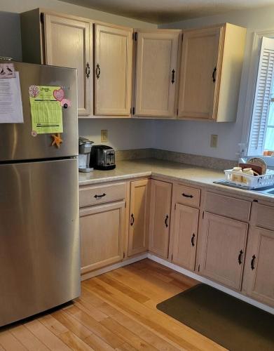 a kitchen with wooden cabinets and a stainless steel refrigerator at Family Retreat at York Beach Y609 Brought to you by GetAway Vacations in York