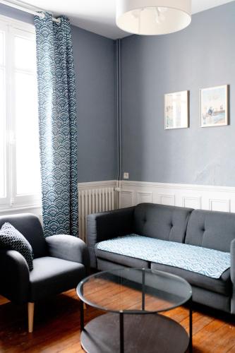 un salon avec un canapé et une table dans l'établissement Villa Zachee - maison familiale & parking gratuit, au Tréport