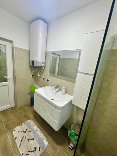 a bathroom with a white sink and a mirror at Mountain Oasis in Valbonë