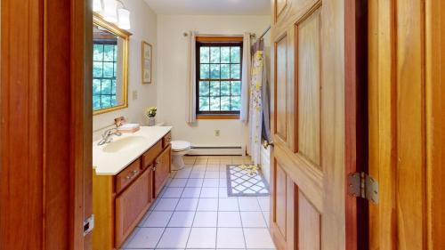 a bathroom with a sink and a toilet and a window at Beechwood Home Brought to you by GetAway Vacations in Rutland
