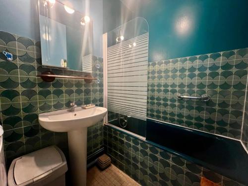 une salle de bain avec un lavabo et un miroir dans l'établissement Le Pédalo - proximité plage, à Wimereux