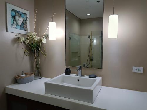 a bathroom with a white sink and a mirror at Miranda 514B 2br at Pico de Loro by Raquel's Place in Nasugbu
