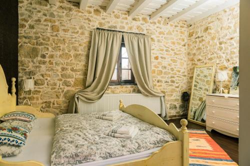 a bedroom with a bed in front of a stone wall at Casa Thea Cheile Nerei in Socolari