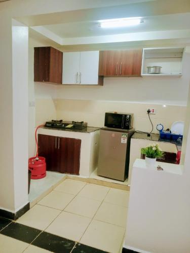 a small kitchen with a stove and a refrigerator at Cozy One bedroom B&B in Thika