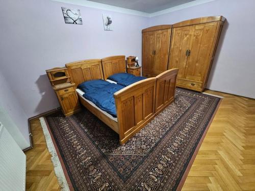 a bedroom with a wooden bed and a rug at Prostorný byt 3+1 pro 4 osob Možnost přistýlky+2os in Šumperk