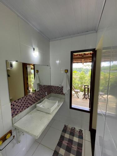 a bathroom with a sink and a mirror at Chalés Paraty Real in Paraty