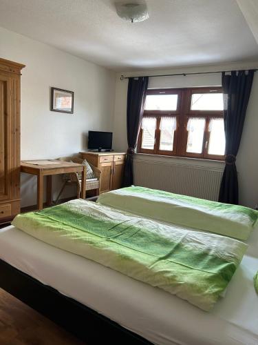 1 dormitorio con 2 camas, escritorio y ventana en Streng's Weinstube, en Sommerach