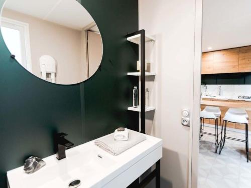 a bathroom with a white sink and a mirror at Camping Les Franquettes - Aquatique Vacances in Grayan-et-lʼHôpital