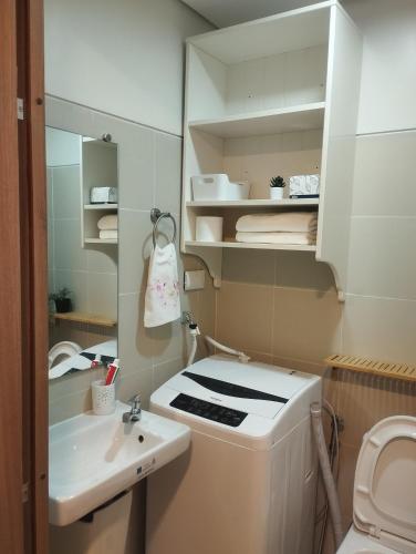 a bathroom with a sink and a toilet and a mirror at S Residences in Manila