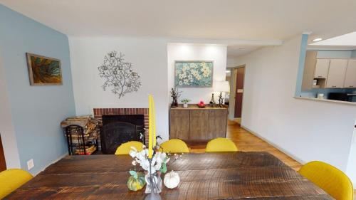 a dining room with a table and a fireplace at Winter Lore Brought to you by GetAway Vacations in Mendon