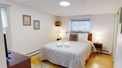a bedroom with a white bed with two candles on it at Winter Lore Brought to you by GetAway Vacations in Mendon
