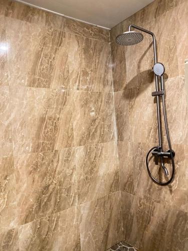 a shower with a shower head in a bathroom at JOSEPHA COTTAGE in Ngurblut