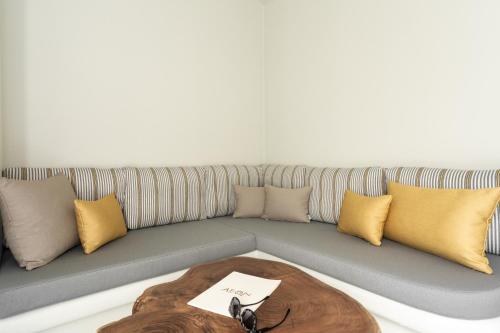 a couch with pillows and a table in front of it at Aeon Suites - Adults Only in Pirgos