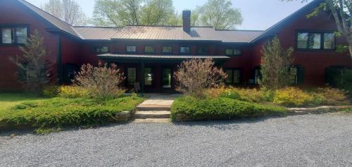 uma casa vermelha com uma entrada em frente em Old Orchard House home em Brandon