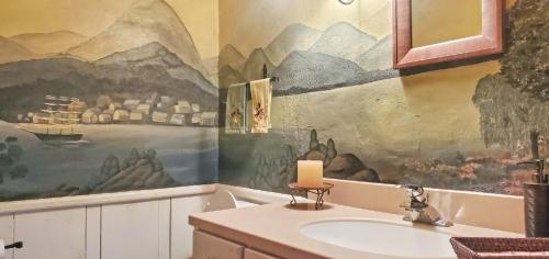 a bathroom with a sink and a painting on the wall at Old Orchard House Brought to you by GetAway Vacations in Brandon