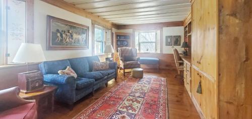 a living room with a blue couch and a rug at Old Orchard House Brought to you by GetAway Vacations in Brandon