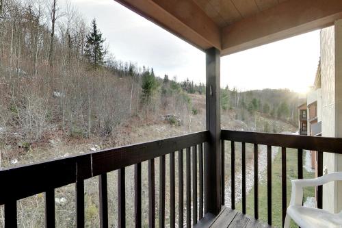 un porche cubierto con vistas al bosque en Pico Village Resort en Killington