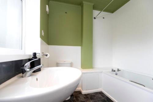 a bathroom with a white tub and a sink at Park House in Durham