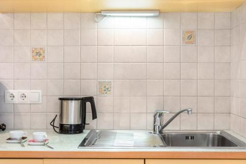 um balcão de cozinha com um lavatório e comodidades para preparar café em Haus Rosengarten Apt A em Terlano