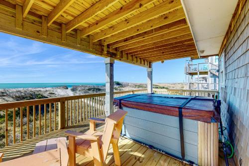 a balcony with a canopy and a table and a chair at Happiness on the Beach in Frisco