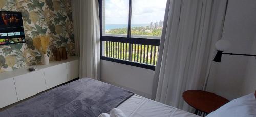 a bedroom with a window with a view of the ocean at COSTE0104 - Premium Stella Maris in Salvador