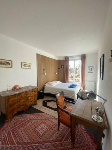 une chambre d'hôtel avec un lit, un bureau et une table dans l'établissement Appartement quartier historique abbaye aux hommes, à Caen