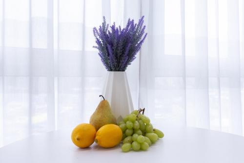 un vaso bianco con un grappolo di uva e frutta di Complex Rogatinskiy a Charkiv