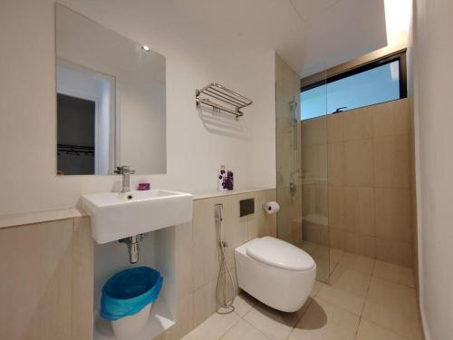 een witte badkamer met een wastafel en een toilet bij Lumi Tropicana 3 Bedroom Golf View # 1-6pax in Petaling Jaya