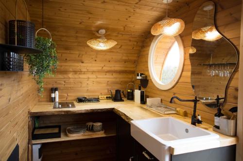 a kitchen with a sink and a counter with wooden walls at Meela Talu Tuulik saunaga in Kuusiku