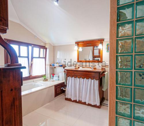 bagno con lavandino, vasca e specchio di La Torrezuca a Boo de Piélagos