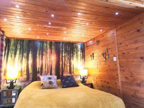 - une chambre avec un lit orné d'une fresque murale d'arbres dans l'établissement Otter 1 HuntersMoon-Warminster-Longleat-Wiltshire, à Warminster