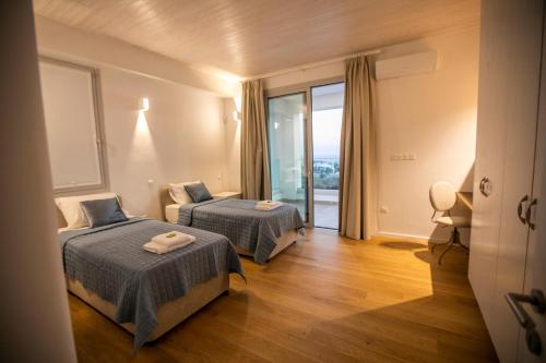 Habitación de hotel con 2 camas y balcón en Villa Kyklamino - Unique Villa with stunning Seaview, en Klorakas