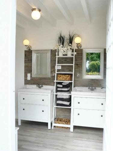 une salle de bain avec deux lavabos et deux miroirs dans l'établissement Villa charmante à Arsac avec piscine privée et jardin, à Arsac