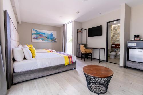 een slaapkamer met een bed, een televisie en een tafel bij Arkana Grupo Amber - Collection O in Puebla
