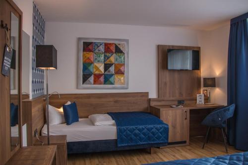 een hotelkamer met een bed en een bureau en een bed sidx sidx sidx sidx bij Hotel am Brauerei-Dreieck in Bamberg