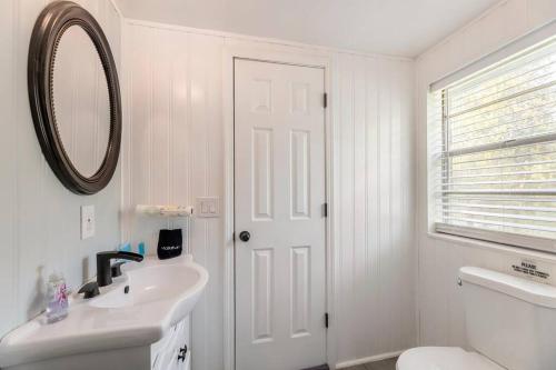 uma casa de banho branca com um lavatório e um espelho em Southern Charm Retreat - 1Bedroom em Irmo
