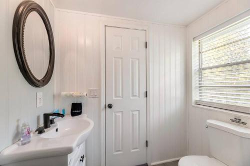 a white bathroom with a sink and a mirror at Southern Charm Retreat - 1Bedroom in Irmo