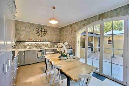 - une cuisine avec une table en bois et des chaises blanches dans l'établissement L'Eden House - Maison hyper centre plages 2min à pied piscine, à Antibes
