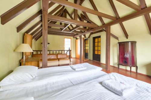 a large white bed in a room with wooden ceilings at Dom & House - Chata Rybaka in Sopot