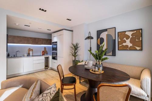 a living room with a table and a kitchen at Executive Luxury apartment in Vauxhall with balcony in London