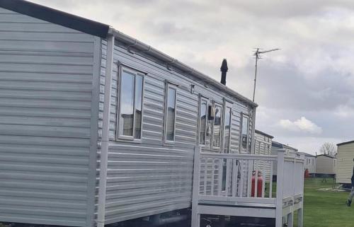 a mobile home with a porch on the side of it at 4-Bedroom Caravan static home in Clacton-on-Sea in Clacton-on-Sea