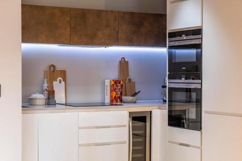cocina con armarios blancos y fogones en Executive Luxury apartment in Vauxhall with balcony, en Londres
