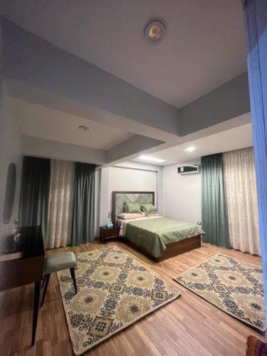 a bedroom with a bed and a table and a rug at شقه فندقيه - هلنان بورفؤاد in Port Said