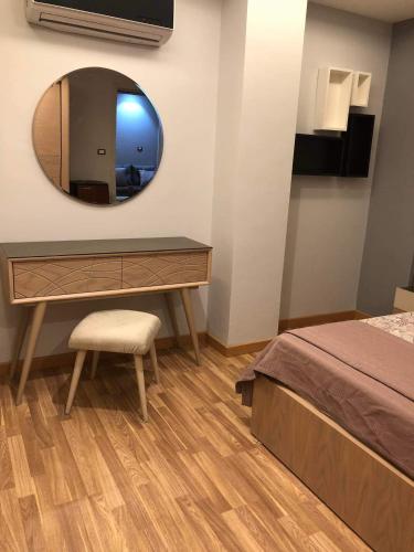 a bedroom with a dressing table and a mirror at شقه فندقيه - هلنان بورفؤاد in Port Said