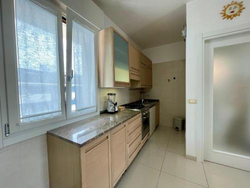 uma cozinha com um lavatório e uma bancada em Appartamento Al Faro I TerraceRelax&Parking em Lignano Sabbiadoro