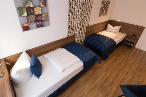 a small room with two beds and a couch at Hotel am Brauerei-Dreieck in Bamberg
